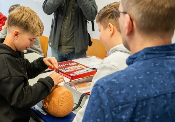 Boys'Day-Teilnehmer üben an einem Puppenkopf im Krankenhaus