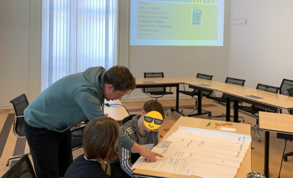 Boys'Day-Teilnehmer mit Mitarbeiter beim Shcreiben von Bewerbungen