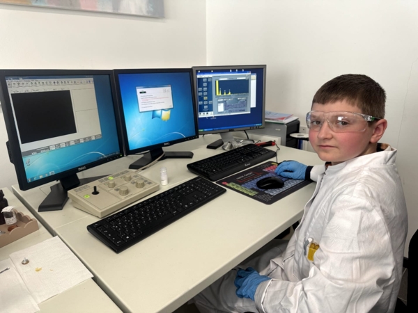 Junge mit Schuutzbrille vor Computer
