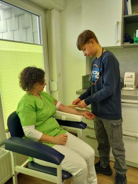Junge nimmt Patientin Blut ab