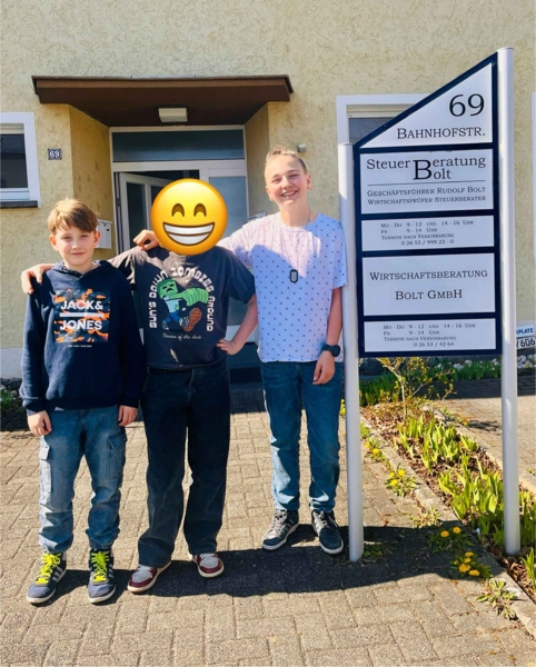 Boys'Day-Teilnehmer mit Mitarbeiterin vor Steuerbüro
