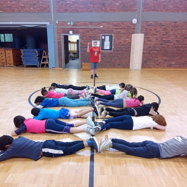 Junge mit Grundschulkindern in der Turnhalle