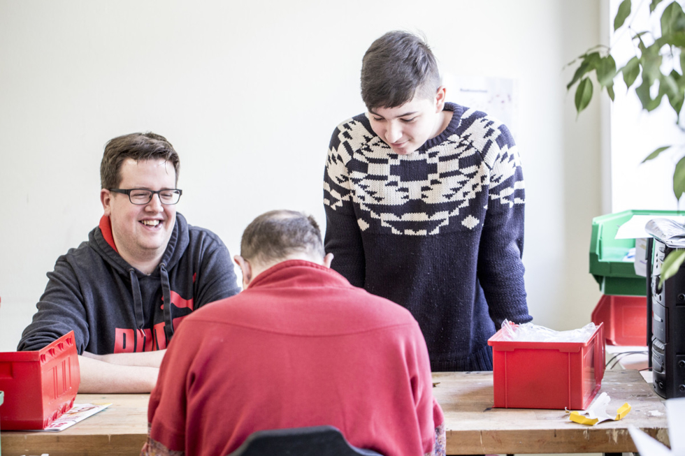 Gruppe von jungen Männern an der Werkbank