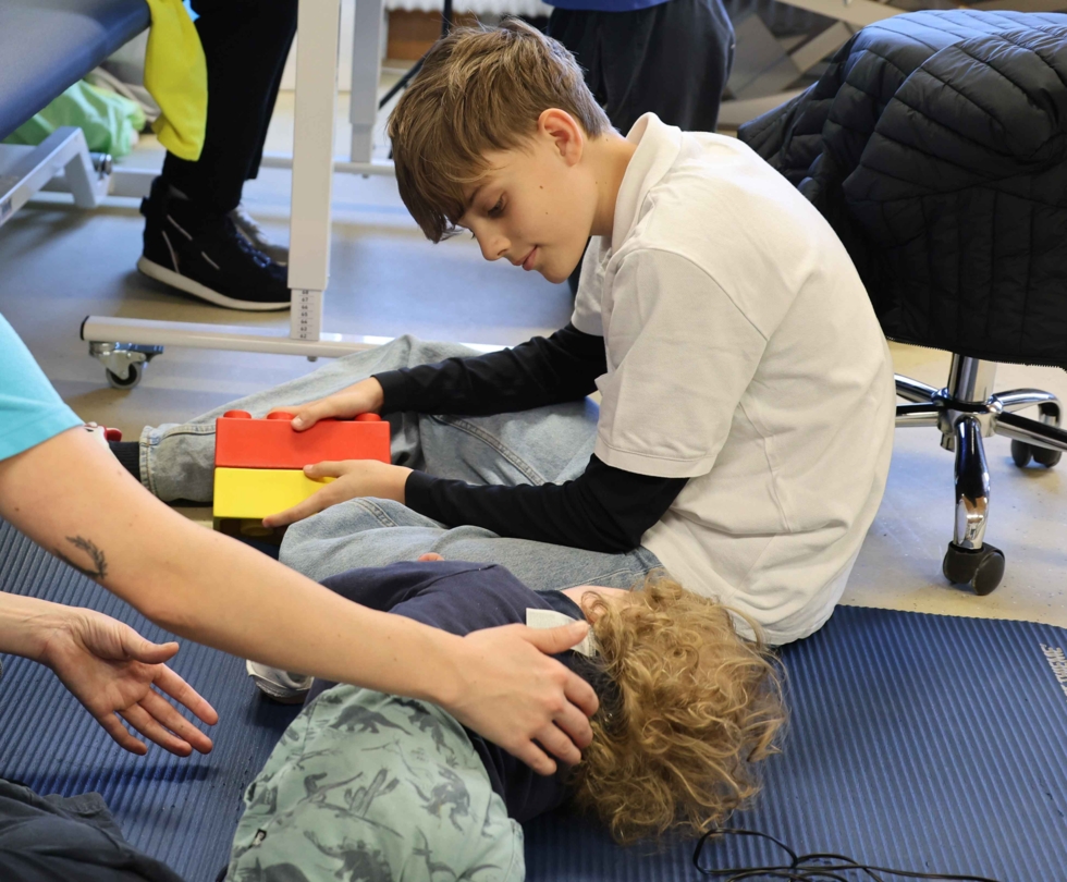 Boys'Day-Teilnehmer schaut sich Ergotherapiebehandlung an