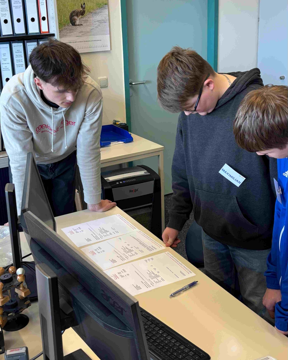 Boys'Day-Teilnehmer schauen sich auf einem Schreibtisch Dokumenta an
