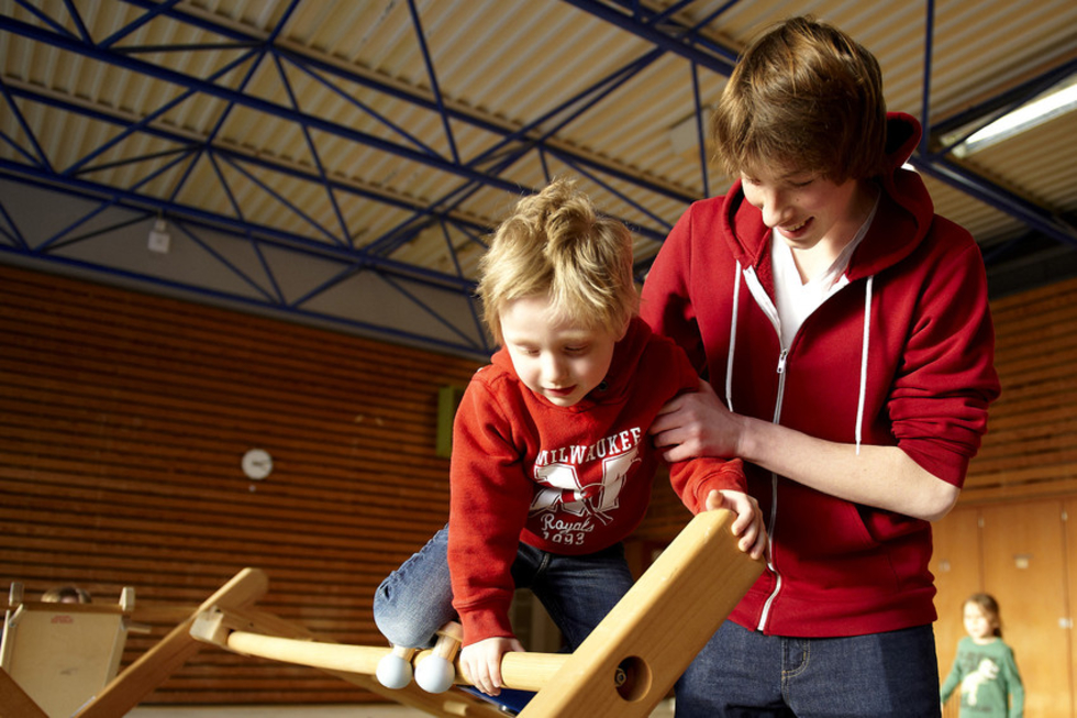 Junger Mann mit Kind in der Turnhalle