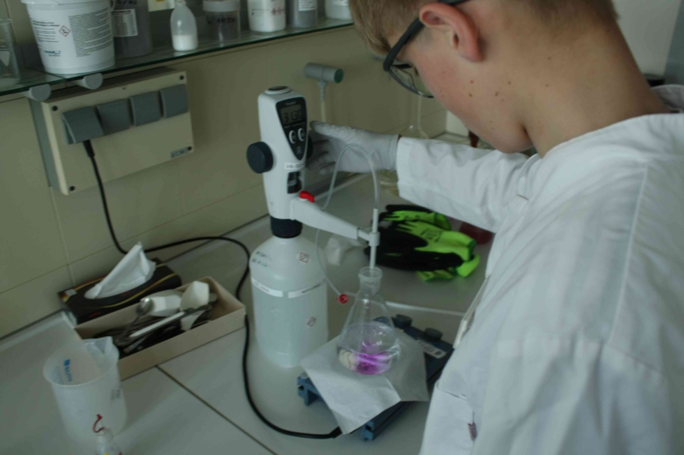Boys'Day-Teilnehmer mit Reagenzglas im Labor