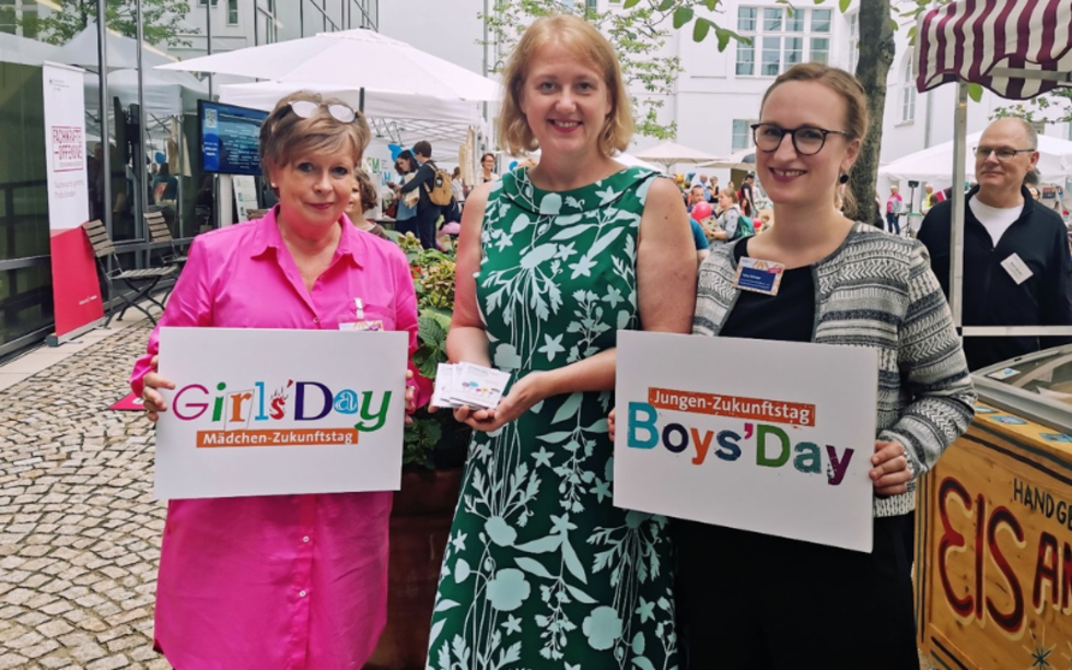 Lisa Paus (Mitte) mit Mitarbeiterinnen des Girls'Day, Boys'Day und der Initiative Klischeefrei, die Schilder mit den Logos in den Händen halten