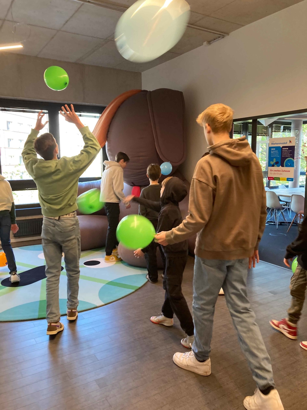 Boys'Day-Teilnehmer mit Kindern beim Ballspiel