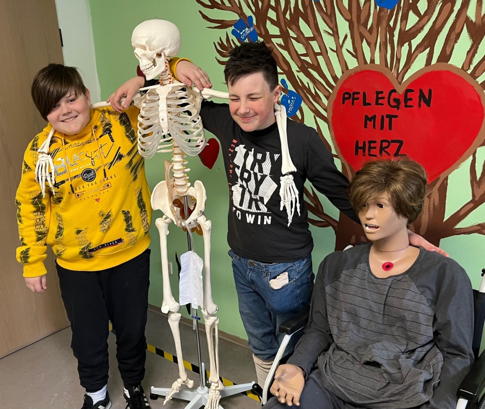 Jungen mit Skelett und medizinischer Puppe