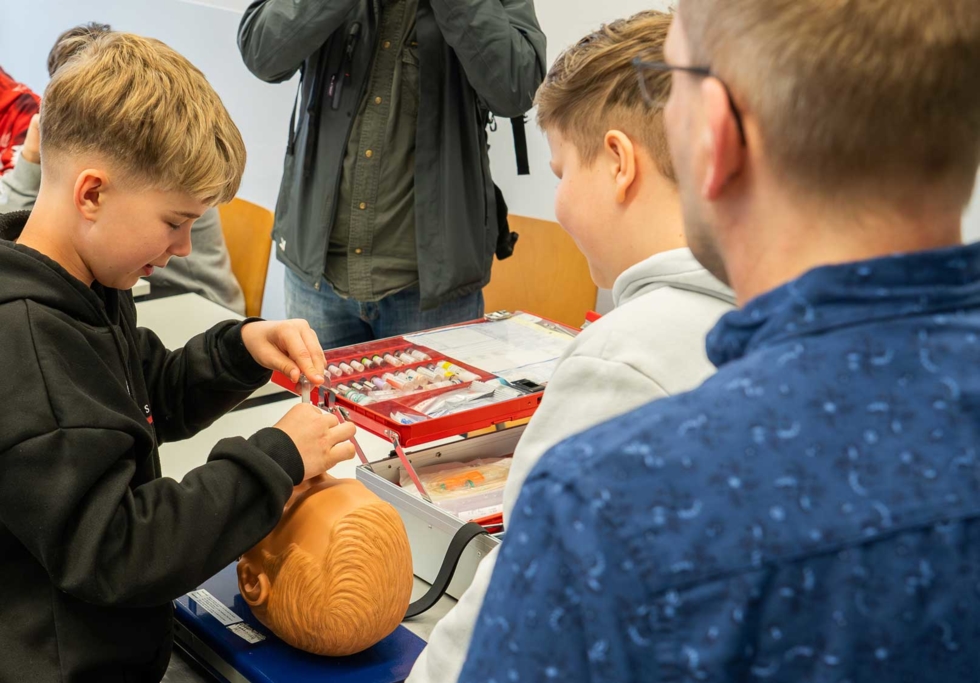 Boys'Day-Teilnehmer üben an einem Puppenkopf im Krankenhaus