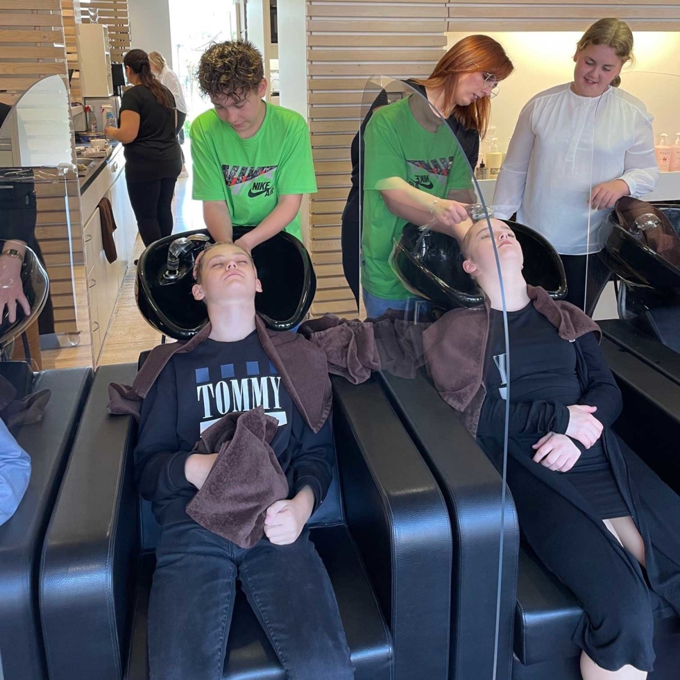 Boys'Day-Teilnehmer beim Haarewaschen im Friseurgeschäft
