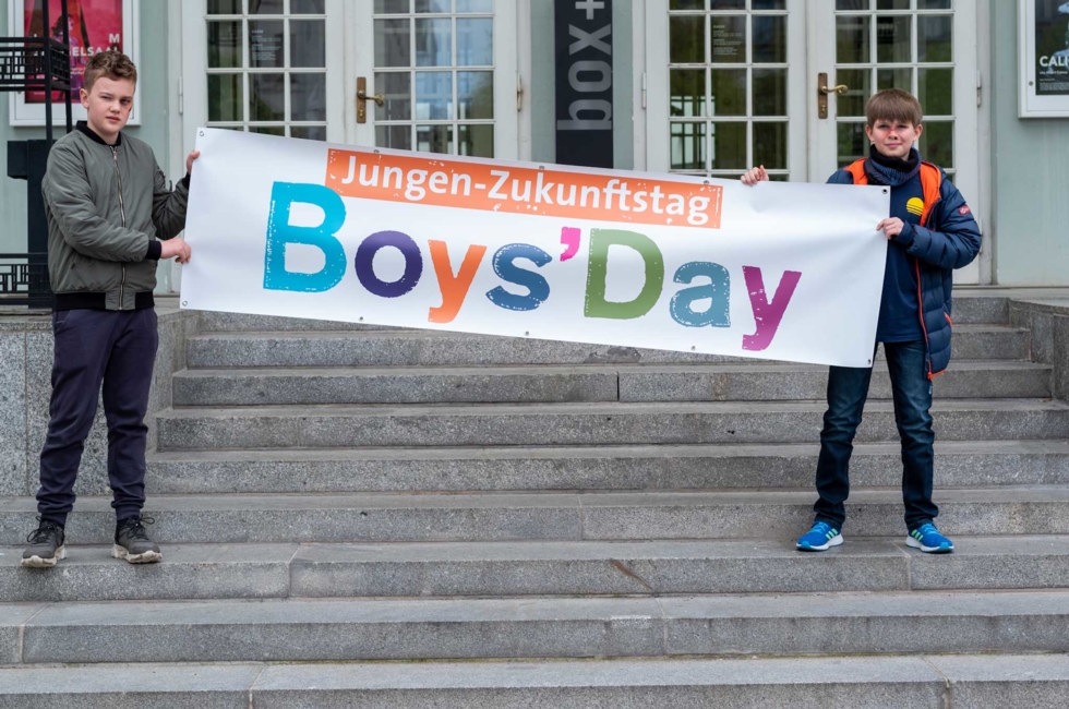 Boys'Day-Teilnehmer vor dem Deutschen Theater mit Boys'Day-Banner
