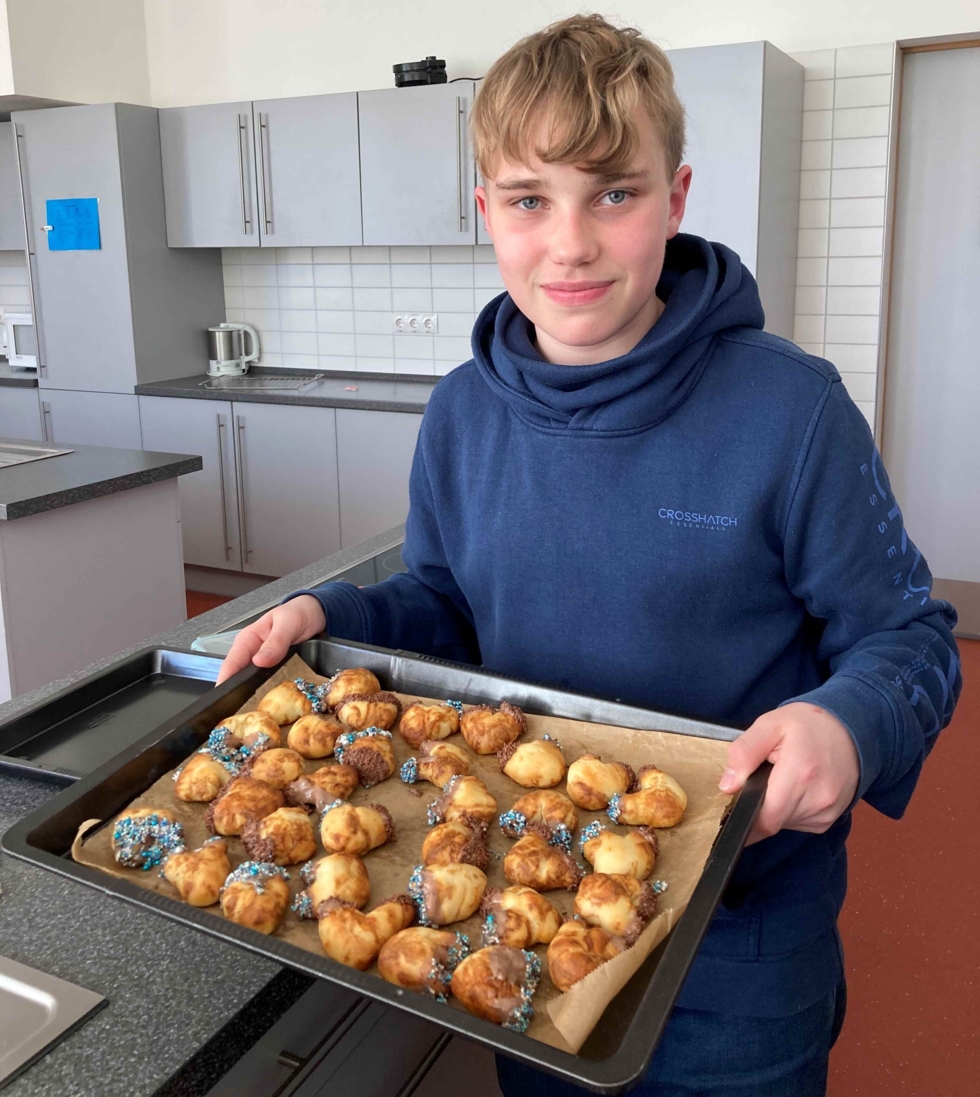 Junge mit Backblech gefüllt mit Gebäck