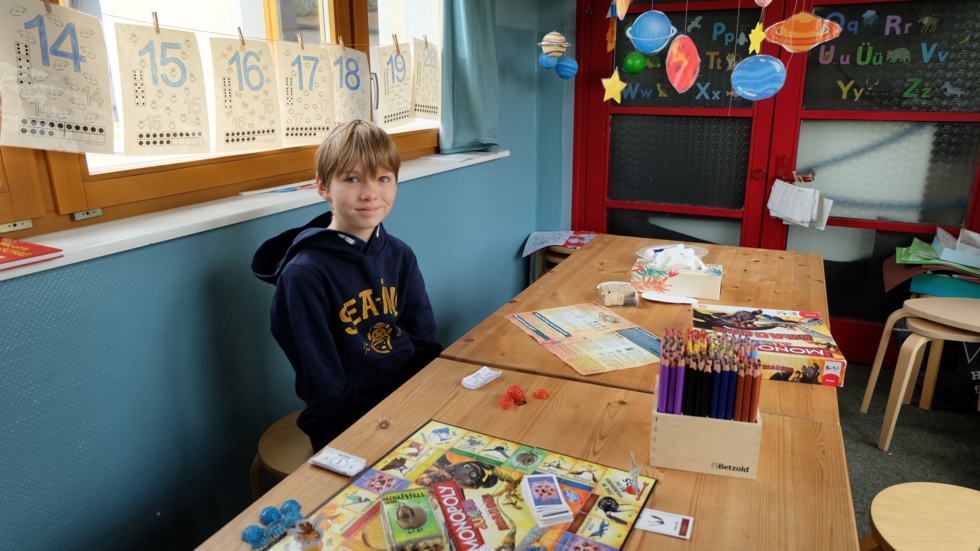 Boys'Day-Teilnehmer am Tisch mit Spiel- und Bastelsachen