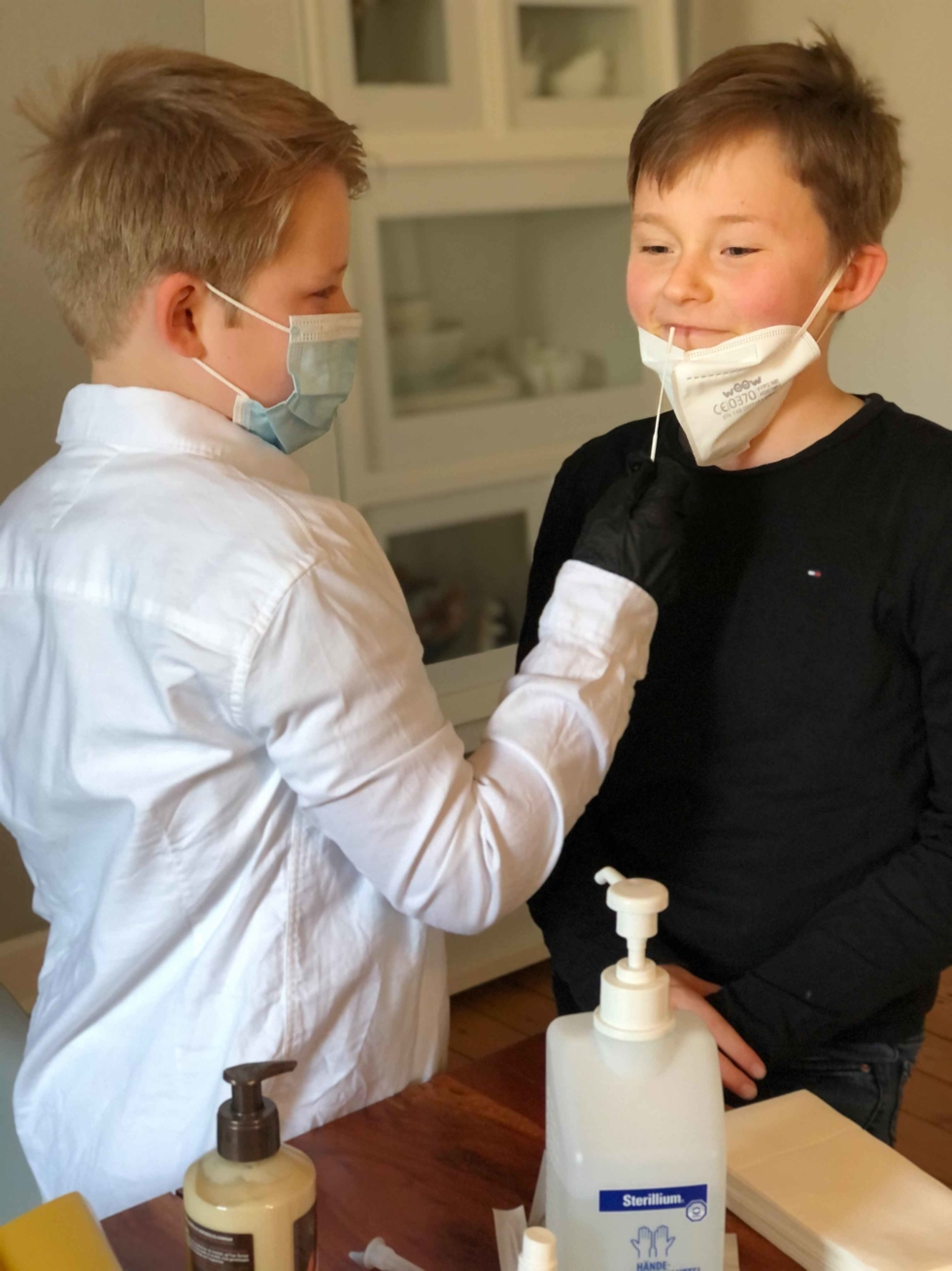 Jungen mit Masken und Coronatests