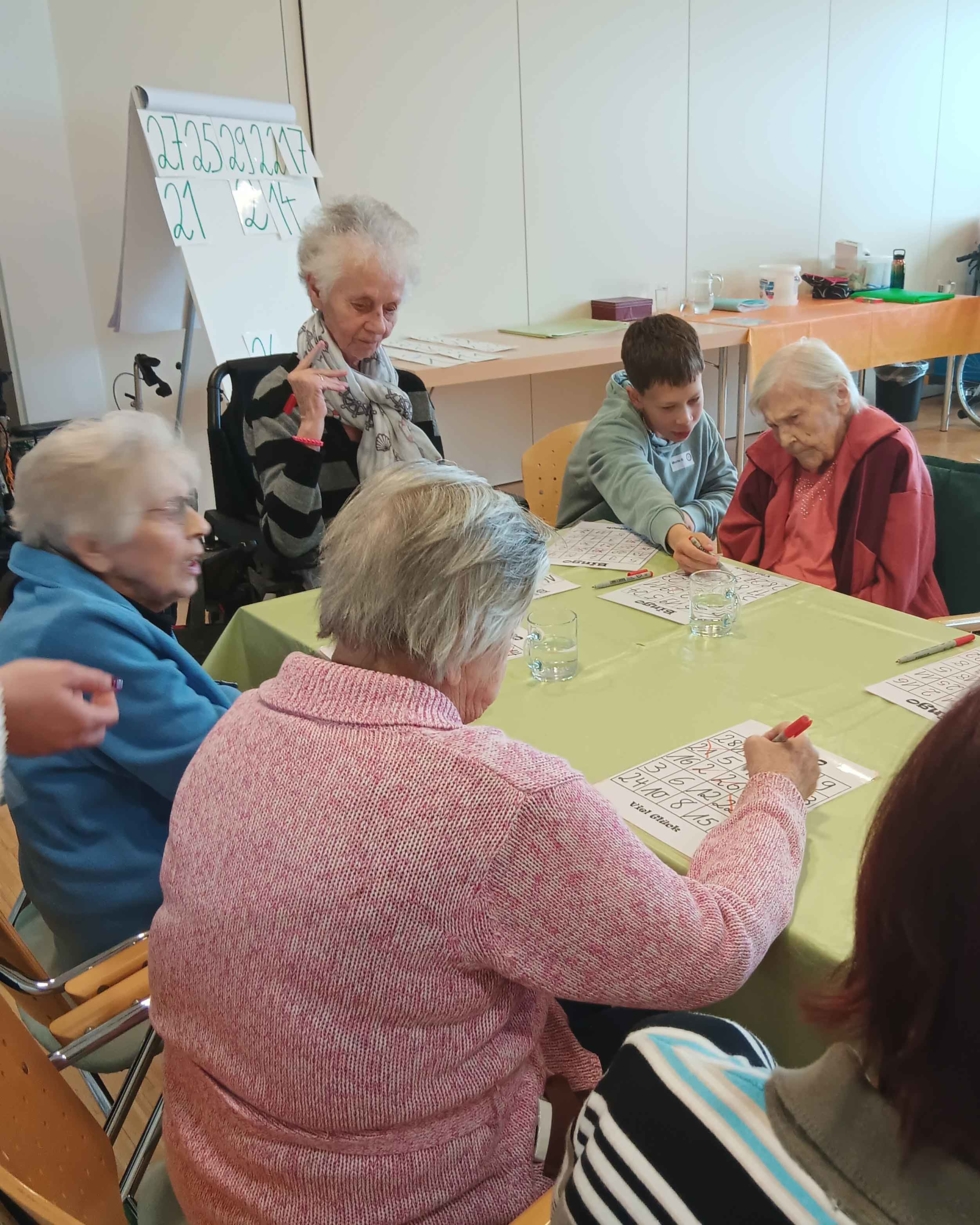 Boys'Day-Teilnehmer mit Seniorinnen beim Bingo